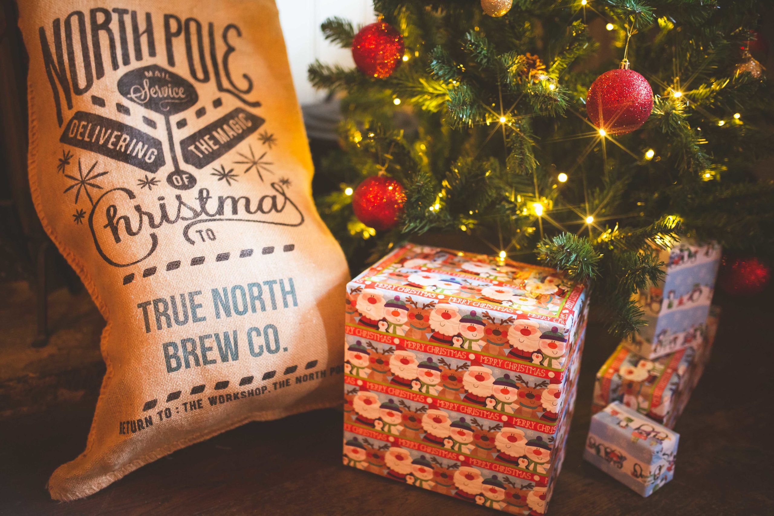 Beautifully wrapped gifts sit under a Christmas tree
